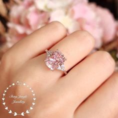 ''Hand made 3-carat eq. (8*10 mm) Cushion cut Fancy Pink diamond simulant engagement ring, with 3 diamond simulants on each side, set in white gold or rose gold plated sterling silver, discreetly adjustable band.'' See a video of this ring here: https://www.instagram.com/p/B9eMgMwlARE/ Unique on Etsy!  This is a stunning ring with a very pretty pastel pink centre stone, we're confident that this ring will make that perfect special gift. It has a marvellous and classic look that definitely stands Wedding Rings Pink Diamond Rose Gold, August Moodboard, Pink Diamond Wedding Rings, Fancy Pink Diamond Ring, Ring 3 Stone, Pink Diamonds Engagement, Pink Engagement, Pink Diamond Engagement Ring, Pink Morganite Engagement Ring