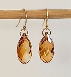 "- Stunning Swarovski Faceted 12mm Crystal Briolettes (2) pair with a center 14K Gold Plated Filigree Bead in this stunning Earring. See Photos #1-2. - Shades of Caramel, Copper, Gold or Orange in this striking Earring. - 14K Gold Plated Roundels for accent. - Drop Length 1 1/2\". - 14K Gold Filled Bali Hook Ear Wires with Ball Ends. - 14K Gold Filled Leverbacks, Angular Hook Ear Wires or 14K Gold Posts (Studs), with 4mm Ball Ends with Backs, upon request, at no cost. Give us a Note on Etsy at C Adjustable Copper Beaded Earrings In Gold, Copper Earrings With Dangling Beads For Gift, Adjustable Copper Beaded Drop Earrings, Elegant Copper Earrings With Dangling Beads, 14k Gold-filled Wire Wrapped Beaded Earrings, Party Earrings, Rainbow Earrings, Shades Of Gold, Gold Copper