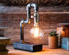 a light bulb sitting on top of a wooden table next to books and a plant