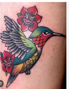 a colorful hummingbird with flowers on its back leg tattoo design for women's thigh