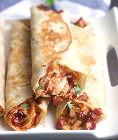 three quesadillas on a white plate with garnishes in the middle