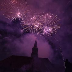 fireworks are lit up the night sky above a church