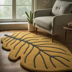 a living room with a couch, chair and rug on the floor in front of a window