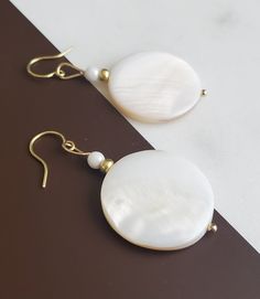 Solazur earrings "Shella" --- Beautiful. Different. Original design. These Solazur summer earrings will add a pop of style and a breeze of glamour to your outfit. Seashells are the best summer and beach reminder, and wearing them will make you feel you're on vacation every day :-)  Modern, romantic, chic and joyful are few words to describe them. I love how beautiful the shell texture glows and reflects from different angles.  They will match beautiful with either a dress or jeans; will make a nice gift idea for any occasion. Or offer them to yourself, no reason needed :-) Each pair is unique - made with two round flat natural shell disc, glass accent beads and brass. ♡ They can be paired with a necklace - sold separately, see link below: https://solazurjewelry.etsy.com/ca/listing/13080686 Brass Earrings Handmade, Shell Texture, Earrings Handmade Beaded, Beach Wedding Jewelry, Earrings Beach, Seashell Earrings, Summer Earrings, Disc Earrings, Summer Earring