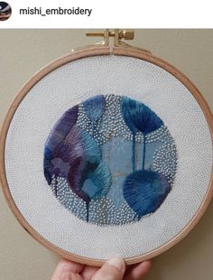 someone is holding up a cross stitch project with blue flowers on it and the text, mish embroidery