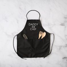 a black apron with utensils on it and the words let's get toasted