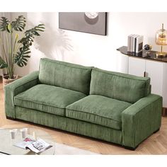 a green couch sitting on top of a hard wood floor