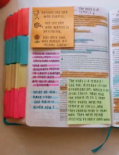 an open bible with colorful sticky notes on the pages and colored crayons attached to it