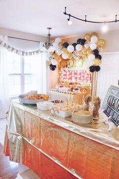 a table topped with lots of food and balloons