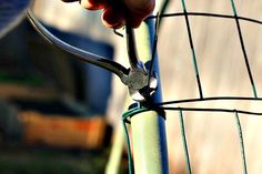 a person is holding onto a wire fence with two pliers attached to the top