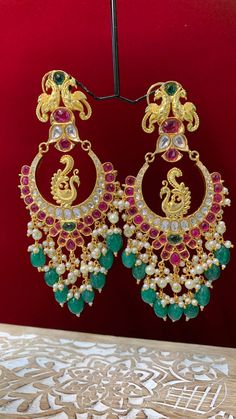 Premium quality High gold plated, pearl work, hand carved work , AD lining and kundan work. Clip back. about 5.5 inch long Absolute designer piece and statement earring. Multicolor Temple Jewelry Chandbalis With Tilla, Multicolor Chandbalis With Tilla In Temple Jewelry Style, Multicolor Chandbalis With Intricate Temple Design, Multicolor Chandbali Earrings With Intricate Design, Festive Chandbali Chandelier Earrings With Peacock Design, Multicolor Chandbali Chandelier Earrings, Multicolor Chandbali Earrings With Cutdana, Multicolor Chandbali Jhumkas With Intricate Design, Multicolor Chandbali Jhumkas With Cutdana