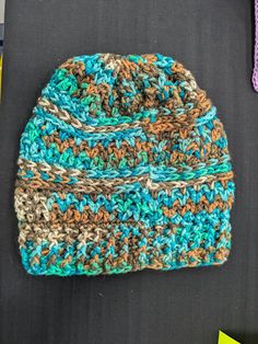 This slouchy hat is made from acrylic yarn in shades of brown, turquoise, and mint green. Will keep you warm during the winter months! Brown Acrylic Hats One Size Fits Most, Cozy Green Fall Hats, Cozy Green Hat One Size Fits Most, Cozy Green Hat For Fall, One Size Brown Crochet Hat In Acrylic Yarn, Green Crochet Hat For Fall, Handmade Blue Fall Hats, Green Yarn Beanie One Size Fits Most, Cozy Brown Acrylic Hat