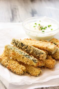 some fried food is sitting on a paper towel next to a small bowl of ranch dressing