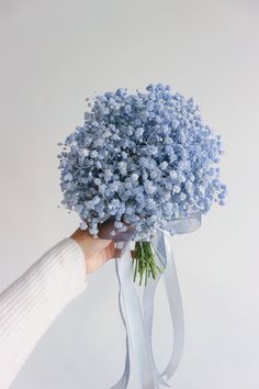 a person holding a bouquet of blue flowers