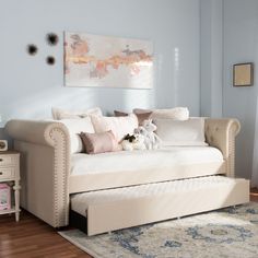 a living room with a couch, rug and painting on the wall above it's bed