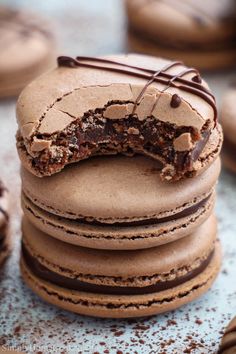 a stack of cookies with chocolate frosting and one broken in the middle, on top of each other