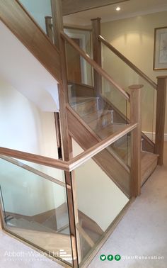 a glass and wood stair case in a room with carpeted flooring on the ground