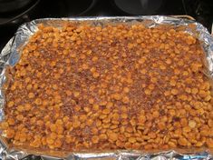 a pan filled with food sitting on top of a stove covered in tin foil next to an oven