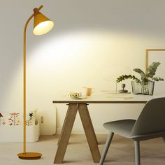 a lamp that is sitting on top of a wooden stand next to a chair and table