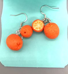 These unique artisan earrings are hand crafted using polymer clay.  Sweet juicy oranges dangle from silver toned earring hooks.  Why not fashionably show your love of oranges?!   Polymer clay is very lightweight and brightly colored.  They are sure to be your favorite pair of earrings! Earrings measure 3/4 inch tall by 3/4 inch wide. Unique Orange Nickel-free Jewelry, Handmade Orange Dangle Jewelry, Orange Earring Jewelry Gift, Handmade Orange Sterling Silver Earrings, Handmade Sterling Silver Orange Earrings, Orange Dangle Earrings Polymer Clay, Orange Dangle Polymer Clay Earrings, Orange Dangle Earrings In Polymer Clay, Orange Dangle Polymer Clay Jewelry