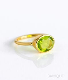 "You'll fall in love with the intense grass-green color of this Peridot Quartz ring. This is a perfectly sized oval to compliment any collection. Popular as a birthday gift for those August babes and peridot lovers alike. This is a bright, transparent green gemstone with no flaws. This stone is beautifully faceted and bezel set in a 925 sterling silver band or plated with 18k vermeil gold. Gemstone is approximately 8 x 12mm. Band has 925 stamp on inside. Please note that each ring is handmade an Green Peridot Birthstone Ring For May, Green Rings With Bezel Setting For May Birthstone, Green Bezel Set Rings For May Birthstone, Green Birthstone Ring With Bezel Setting, Open Design, Green Birthstone Ring With Bezel Setting, Green Birthstone Ring With Bezel Setting And Open Shape, Green Gemstone Birthstone Ring For Promise, Lime Green Gemstone Birthstone Ring As Gift, Lime Green Gemstone Birthstone Ring For Gift