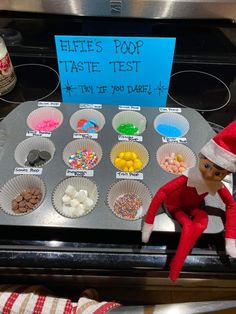 an elf is sitting on top of a baking pan with candy and candies in it