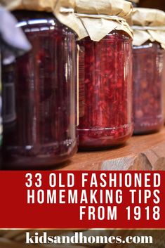 three jars filled with red liquid sitting on top of a wooden shelf next to a bag