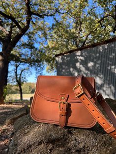 The Marlondo Leather Saddle Crossbody Purse is a vintage inspired saddle bag purse, perfect for weekend adventures and everyday carry. This purse has a belted buckle closure for a timeless chic look. The Saddle Crossbody features an interior pocket and two slot pockets on the bag's exterior: one across the rear of the bag and another just under the main flap. The Saddle Crossbody also comes with an adjustable and removable strap. The Marlondo Leather Crossbody is made with beautiful full grain v Saddle Bag Purse, Weekend Adventures, Timeless Chic, Tan Cowhide, Saddle Bag, Everyday Carry, Vegetable Tanned Leather, Crossbody Purse, Saddle Bags