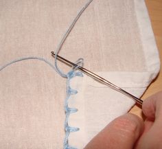 someone is stitching something on the side of a piece of fabric with a needle