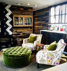 a living room filled with furniture and a fire place next to a wall covered in wood planks