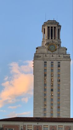 a tall building with a clock on it's face in front of a cloudy sky