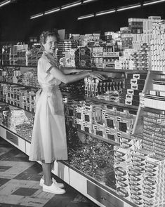 a woman standing in front of a store display filled with items