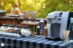 a table topped with lots of food next to a coffee maker and ice cream dispenser