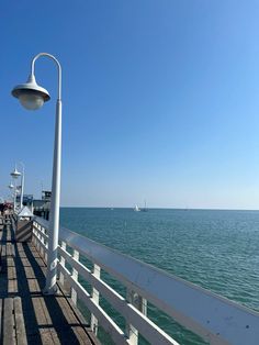 the pier is next to the ocean with boats in the water