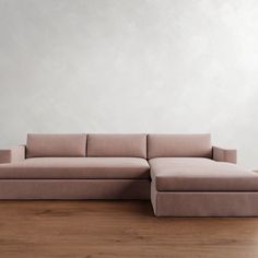 a couch sitting on top of a hard wood floor next to a white wall in an empty room