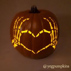 a carved pumpkin with the shape of a heart on it's face and hands