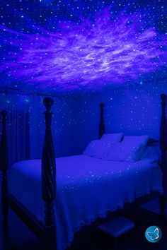 a bed in a room with blue lights on the ceiling and stars painted on the walls