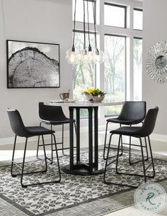 a dining table with four chairs and a bowl of flowers on the table in front of it