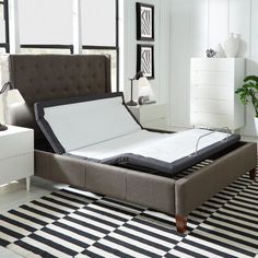 a bed that is sitting on top of a black and white rug