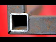 a square metal object on a red background