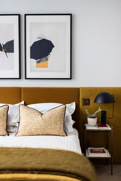 two framed pictures hang above a bed in a bedroom