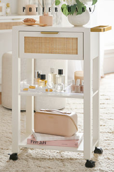 a white table topped with lots of beauty products and a vase filled with pink flowers