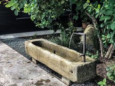 a stone bathtub sitting in the middle of a garden