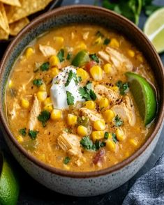 a bowl of chicken tortilla soup with corn and cilantro