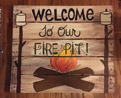 a wooden sign that says welcome to our firepit with a campfire on it