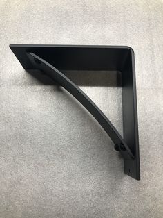 the corner of a shelf is shown with an angled end and black metal brackets on it