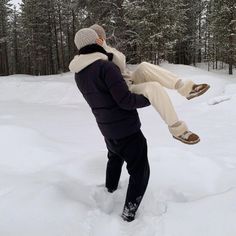 a man holding onto another person in the snow