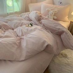 an unmade bed with white sheets and pillows