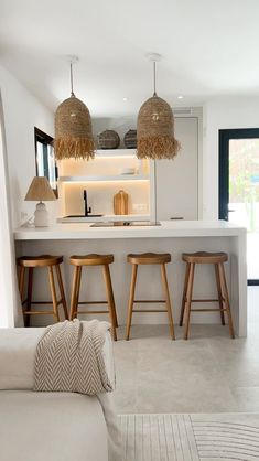 a living room filled with furniture next to a kitchen