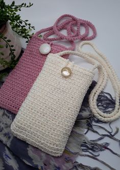 two crocheted purses sitting next to each other on top of a table